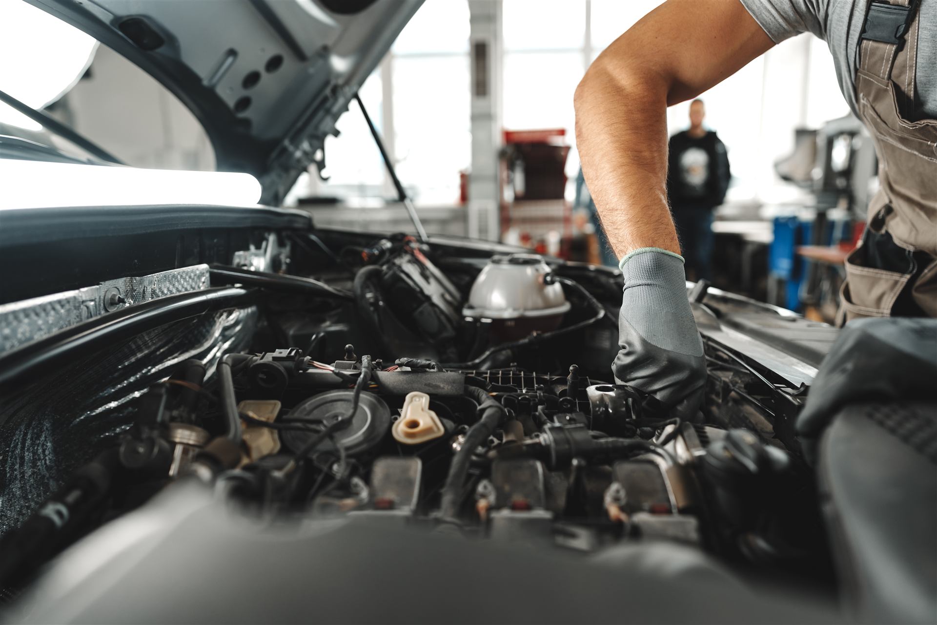 Mechaniker-Hände bei der Arbeit am Motor