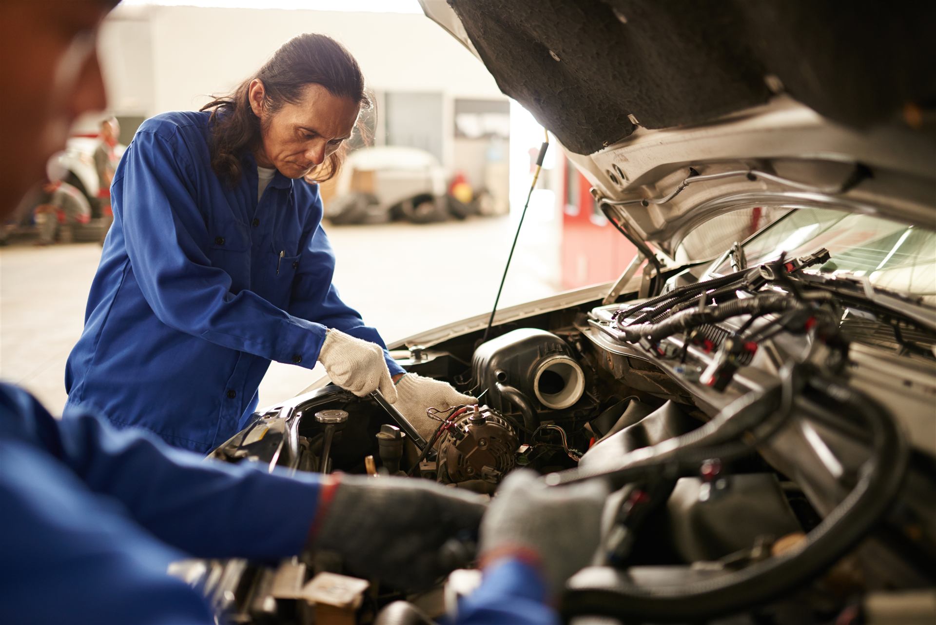 Zwei Mechaniker arbeiten gemeinsam am Motor