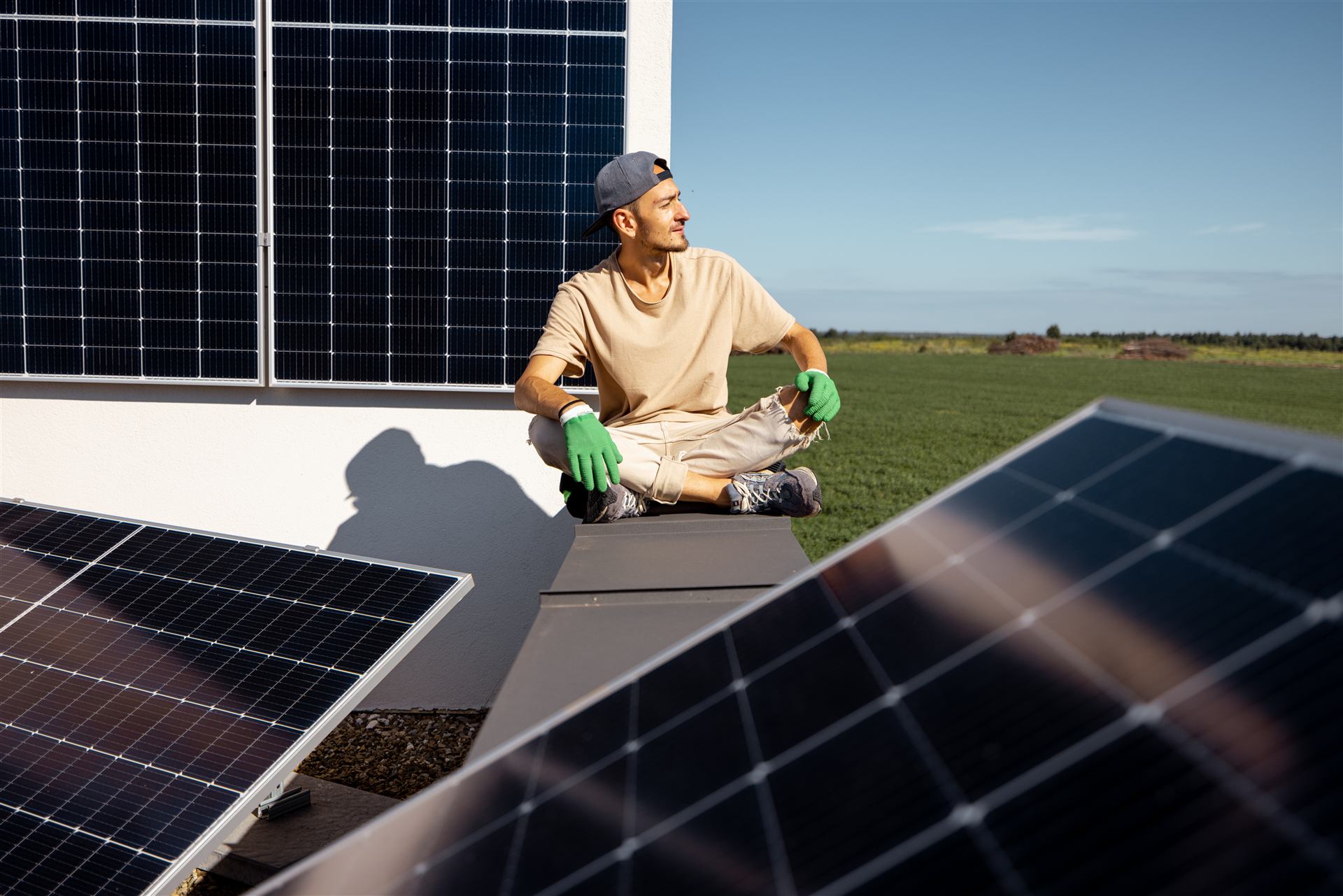 Zufriedener Hausbesitzer auf seinem Dach mit neuer Solaranlage